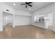 Open-concept living area showcasing wood-look tile flooring, a ceiling fan, and a partial view into the modern kitchen at 13677 N 108Th Dr, Sun City, AZ 85351