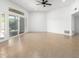 Large living room with wood-look tile, white walls, recessed lighting, and a sliding glass door at 13677 N 108Th Dr, Sun City, AZ 85351