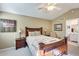 Cozy bedroom features a ceiling fan, neutral walls, and a decorative fish-themed quilt and throw pillows at 14385 W Morning Star Trl, Surprise, AZ 85374