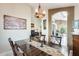 Inviting dining area with dark wood table and chairs, decorative chandelier and access to multiple living areas at 14385 W Morning Star Trl, Surprise, AZ 85374