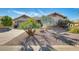 Charming home featuring desert landscaping, paved driveway, and architectural details at 14385 W Morning Star Trl, Surprise, AZ 85374