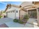 The front exterior showcases beautiful landscaping, a tile roof, and a charming front entry gate at 14385 W Morning Star Trl, Surprise, AZ 85374