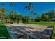 Outdoor horseshoe pit area for residents, complemented by vibrant landscaping and swaying palm trees in the distance at 14385 W Morning Star Trl, Surprise, AZ 85374