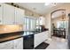 Well-lit kitchen with white cabinets, black countertops, and stainless-steel appliances at 14385 W Morning Star Trl, Surprise, AZ 85374