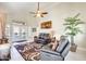 Well-lit living room featuring comfortable sofas, tile floors, and French doors at 14385 W Morning Star Trl, Surprise, AZ 85374