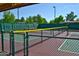 Outdoor pickleball court featuring a green and red court surface, covered from the elements, with greenery behind the fence at 14385 W Morning Star Trl, Surprise, AZ 85374