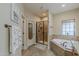 This bathroom features a glass enclosed shower and a large soaking tub beneath a window at 1440 W Christie Lyn Ln, San Tan Valley, AZ 85144