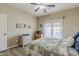 A cozy bedroom featuring a ceiling fan, white door, dresser, and queen size bed with comfortable bedding at 1440 W Christie Lyn Ln, San Tan Valley, AZ 85144