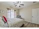 Cozy bedroom with a ceiling fan, plush chair, and bright window with decorative curtains at 1440 W Christie Lyn Ln, San Tan Valley, AZ 85144