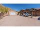 Driveway featuring a covered parking area, an additional garage, and a well-maintained gravel surface at 1440 W Christie Lyn Ln, San Tan Valley, AZ 85144