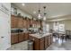 Well-lit kitchen boasts granite counters, stainless steel appliances, kitchen island and light-colored tile flooring at 1440 W Christie Lyn Ln, San Tan Valley, AZ 85144