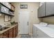 A functional laundry room with modern washer and dryer, sink, countertop, cabinets, and a 'Laundry Co' sign at 1440 W Christie Lyn Ln, San Tan Valley, AZ 85144