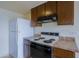 Close-up of the kitchen featuring a white refrigerator, electric range, and updated laminate countertops at 14620 N Yerba Buena Way # D, Fountain Hills, AZ 85268