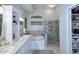 Elegant bathroom featuring dual sinks, a soaking tub, a walk-in shower, and custom storage solutions at 15273 N 92Nd Pl, Scottsdale, AZ 85260