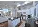 Bright kitchen with stainless steel appliances, white cabinets, and black countertops, showcasing modern design at 15273 N 92Nd Pl, Scottsdale, AZ 85260