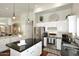 Bright kitchen with stainless appliances, black countertops, and white cabinetry at 15273 N 92Nd Pl, Scottsdale, AZ 85260