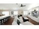 Open-concept living area with hardwood floors, stone fireplace, and built-in cabinets under a fan at 15273 N 92Nd Pl, Scottsdale, AZ 85260