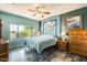 Bright bedroom featuring a large window, ceiling fan and stylish gray floor tiling at 15840 W Falcon Ridge Dr, Sun City West, AZ 85375