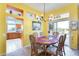 Dining area with sunny yellow walls, stylish chandelier, and easy access to kitchen at 15840 W Falcon Ridge Dr, Sun City West, AZ 85375