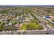 Aerial view of a park nestled within a neighborhood, featuring a grassy field and mature trees in the landscape at 16939 W Marconi Ave, Surprise, AZ 85388