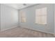 Bright bedroom with neutral carpet and walls featuring two windows letting in natural light at 16939 W Marconi Ave, Surprise, AZ 85388