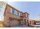 Side view of a two-story home showcasing a two-car garage, arched entry, and desert landscaping at 16939 W Marconi Ave, Surprise, AZ 85388