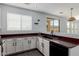 Bright kitchen featuring white cabinets, dark countertops, black sink and stainless steel appliances at 16939 W Marconi Ave, Surprise, AZ 85388