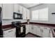 Well-lit kitchen with white cabinets, dark countertops, and modern black appliances at 16939 W Marconi Ave, Surprise, AZ 85388