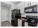 Functional kitchen with white cabinets, dark countertops, black fridge and range oven at 16939 W Marconi Ave, Surprise, AZ 85388