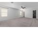 Spacious main bedroom featuring carpet floors, ceiling fan, and ample natural light at 16939 W Marconi Ave, Surprise, AZ 85388