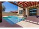 Backyard pool view under shaded pergola with outside seating and potted plants at 16939 W Marconi Ave, Surprise, AZ 85388