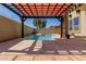 Backyard pool view under shaded pergola with outside seating and potted plants at 16939 W Marconi Ave, Surprise, AZ 85388