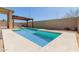 A clean backyard pool with a pergola and patio seating at 16939 W Marconi Ave, Surprise, AZ 85388