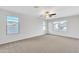 Spacious bedroom with plush carpeting, a ceiling fan, and bright natural light from the multiple windows at 1715 E Branham Ln, Phoenix, AZ 85042