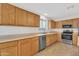 Functional kitchen showcasing oak cabinetry and sleek stainless steel appliances at 1715 E Branham Ln, Phoenix, AZ 85042