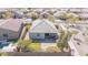 Aerial view of landscaped backyard featuring a covered patio, green turf area, and a rejuvenating hot tub at 17796 W Sandy Rd, Goodyear, AZ 85338