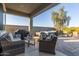 Back patio featuring a hot tub, paver deck, and cozy wicker furniture with a grill at 17796 W Sandy Rd, Goodyear, AZ 85338