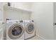 Bright laundry room featuring a Samsung washer, Samsung dryer, and storage shelves at 17796 W Sandy Rd, Goodyear, AZ 85338