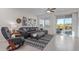 Spacious living room featuring a large sectional sofa, ceiling fan, and sliding doors to the backyard at 17796 W Sandy Rd, Goodyear, AZ 85338