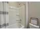 Clean bathroom features a shower over tub, with a modern shower head and a decorative shower curtain at 18385 W Devonshire Ave, Goodyear, AZ 85395