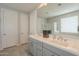 Bathroom featuring a double vanity with gray cabinetry, a large mirror, and a shower with glass doors at 18385 W Devonshire Ave, Goodyear, AZ 85395