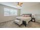 Cozy bedroom featuring plush carpet, a ceiling fan, neutral paint, and a comfortable bed with stylish bedding at 18385 W Devonshire Ave, Goodyear, AZ 85395