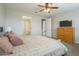 Bedroom featuring neutral paint, a ceiling fan, and a stylish wooden dresser with a flat screen TV at 18385 W Devonshire Ave, Goodyear, AZ 85395