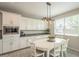 Eat-in kitchen featuring a dining area with a round table, white chairs, and modern lighting at 18385 W Devonshire Ave, Goodyear, AZ 85395