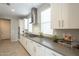 Stylish kitchen with white cabinetry, stainless steel appliances, and gray countertops at 18385 W Devonshire Ave, Goodyear, AZ 85395