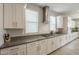 Bright kitchen featuring white cabinets, a sleek gas range, stainless vent hood, and gray countertops at 18385 W Devonshire Ave, Goodyear, AZ 85395