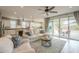 Bright open-concept living room with neutral decor, sliding glass doors, and view into kitchen at 18385 W Devonshire Ave, Goodyear, AZ 85395