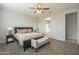 Serene main bedroom with a decorative bed, bench, soft lighting, and a glimpse into the en-suite bathroom at 18385 W Devonshire Ave, Goodyear, AZ 85395