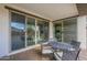 Covered patio featuring a round table and chairs with sliding glass doors leading into the home at 18385 W Devonshire Ave, Goodyear, AZ 85395