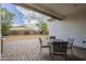 Covered patio area with pavers, a table and chairs, and an outdoor view at 18385 W Devonshire Ave, Goodyear, AZ 85395